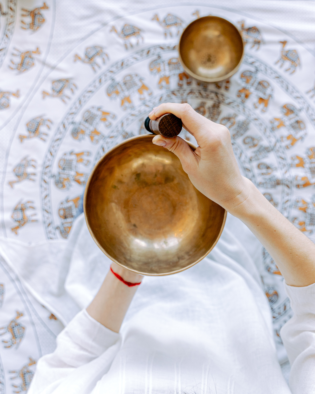 Hands playing singing bowls during a sound therapy practice
